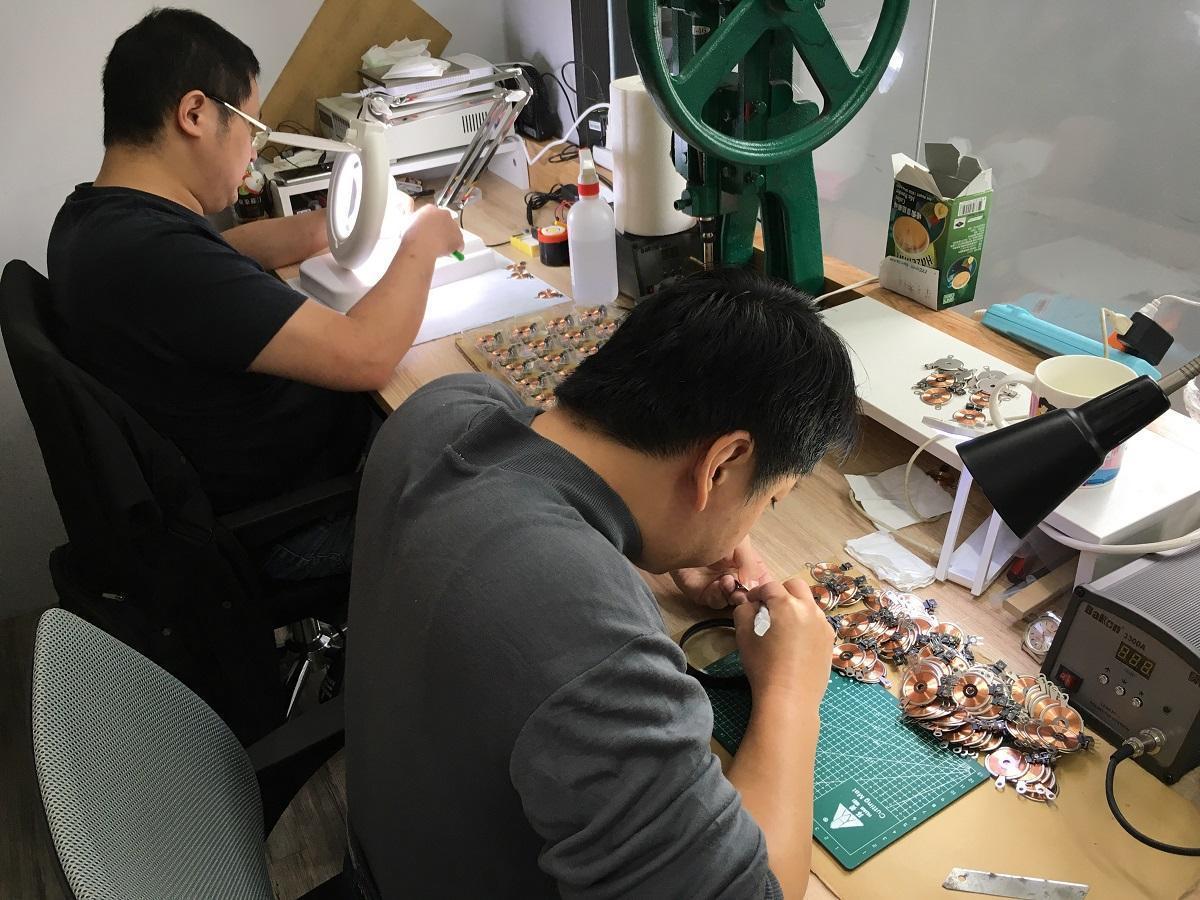 The workers examine the parts carefully before assembling the programmable music box Muro Box to ensure its sound quality and stability.