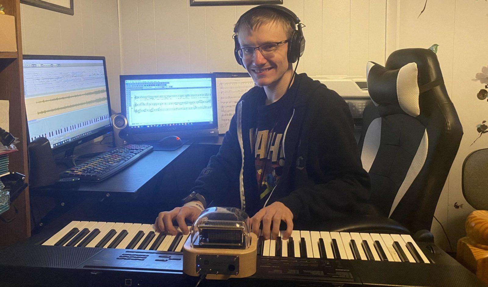 Josh Keeler is playing the programmable music box Muro Box in his studio. and there are a MIDI keyboard and computer next to the Music Box.