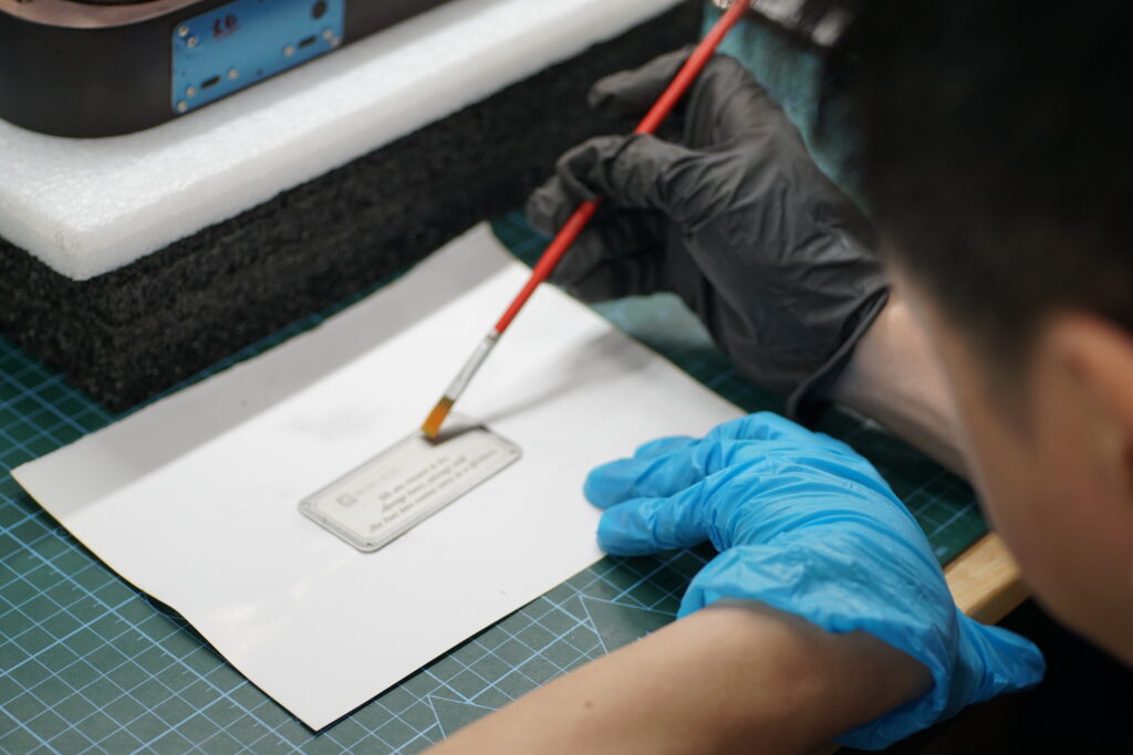 Customized Engraving Step 5 – The production team applies a protective coating to the nameplate.