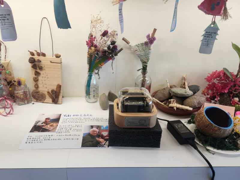 Muro Box-N20音樂盒放置在安寧病房的交誼廳靜靜演奏著耶誕歌曲，周邊放置了每個家屬寫給家人的祝福與思念文字小卡以及永生花。有張白紙上印著兩張照片是翁先生與他媽媽的生活照與這段安寧照顧時期的回憶。