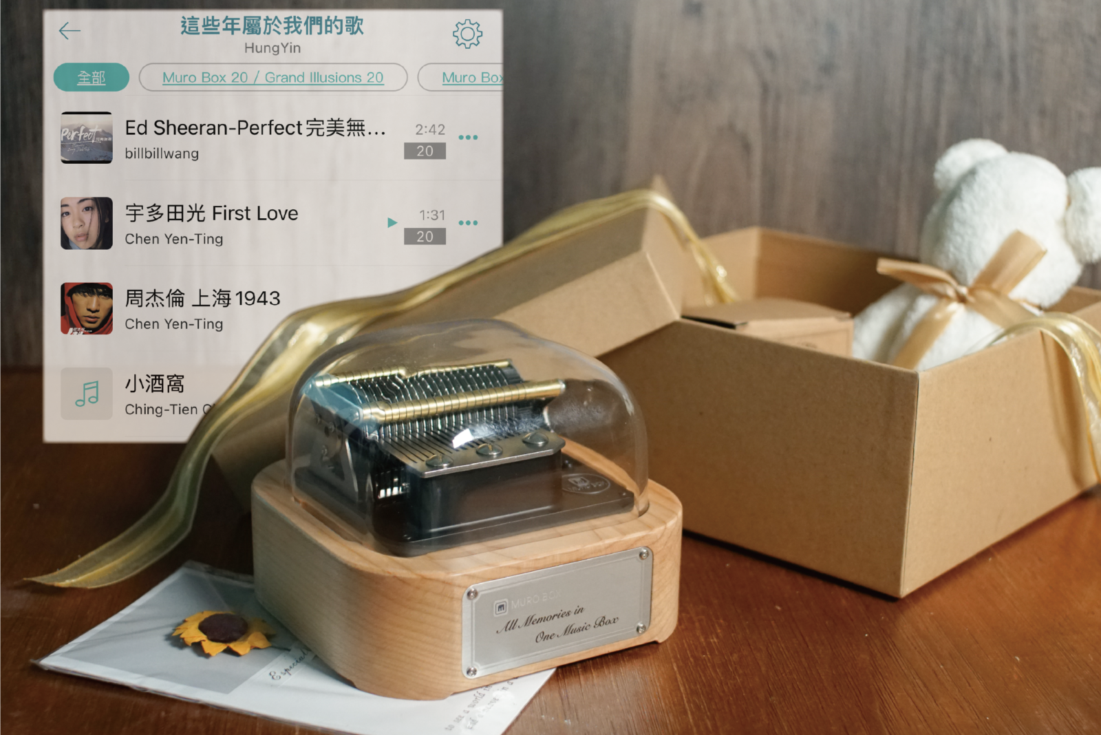 智慧音樂盒Muro Box-N20 標準版在前景，背後的APP歌單畫面是一位中文客戶在Muro Box App 內公開分享的歌單內容所做的示意圖。